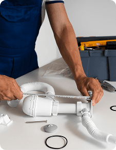 Plumber working on pipes under a sink